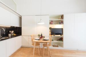 a dining room with a table and chairs in a kitchen at Bright Downtown Apartment in Porto +12 photos