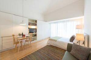 1 dormitorio con cama, mesa y escritorio en Bright Downtown Apartment, en Oporto