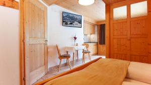 a bedroom with a bed and a table with a chair at Apartments B&B Pretermo in Badia