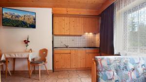 a kitchen with wooden cabinets and a table and a window at Apartments B&B Pretermo in Badia
