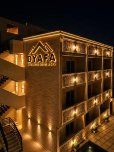 a building with a sign on it at night at Dyafa Pyramids Hotel in Cairo