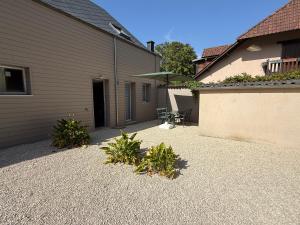 a yard with a building and a patio with plants at Chtî arq in Arques-la-Bataille