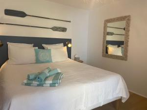a bedroom with a white bed with a mirror at Le Mas de Caroline in Gargas