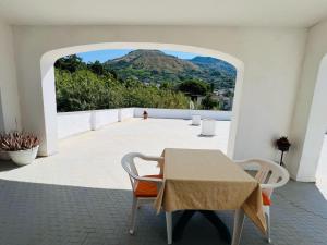 a table and chairs on a patio with a view of a mountain at Villa Thomas BB conduzione familiare in Forio d'Ischia