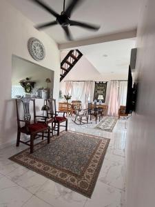 a living room with a table and chairs and a ceiling fan at Homestay Kamila Mersing in Mersing