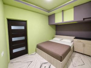 a small bedroom with a bed and a door at Ila Travel Yerevan in Yerevan