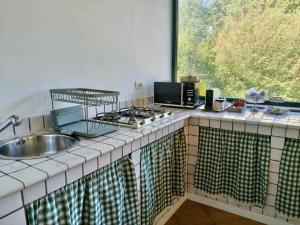 a kitchen with a stove and a sink and a window at Il giardino delle cince in Borgo Ticino