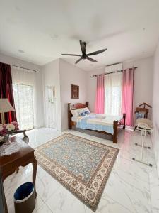 a bedroom with a bed and a ceiling fan at Homestay Kamila Mersing in Mersing +31 photos