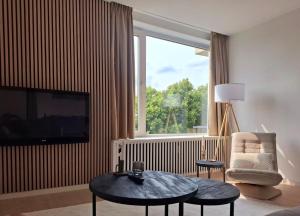 a living room with a television and a table and a chair at Apartment with skyline view in Eindhoven