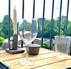 a table with two wine glasses and a candle at Apartment with skyline view in Eindhoven