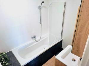 a bathroom with a shower and a tub and a sink at Apartment with skyline view in Eindhoven +14 photos
