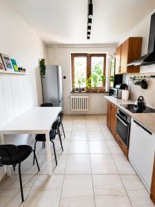 a kitchen with a white table and a table and chairs at Zielone drzwi in Żywiec +12 photos