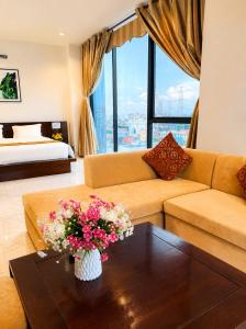 a living room with a couch and a table with flowers at Royal ANAN Hotel in Ninh Binh +36 photos
