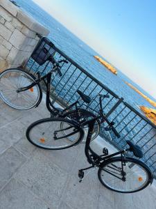 two bikes parked next to a fence near the ocean at Wonderhouse in Polignano a Mare