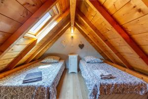 a bedroom with two beds in a attic at Gîte Viscos - L'escapade en famille l Ô Domaine de Geu in Geu