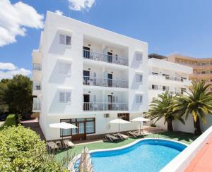 een groot wit gebouw met een zwembad ervoor bij Apartamentos Sofía in Es Cana