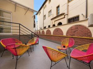 a group of chairs and tables on a balcony at Lev Or Aparthotel in Bucharest