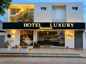 a hotel lobby with a hotel luxury sign on a building at HOTEL LUXURY v in Valledupar