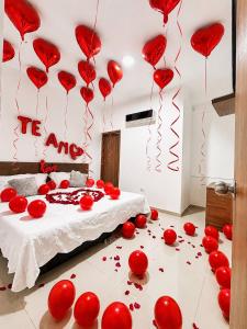 a bedroom with red hearts on the floor and balloons at HOTEL LUXURY v in Valledupar