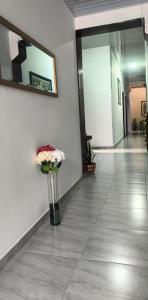 a vase of flowers sitting on the floor in a hallway at Hotel Matias Real in Buga