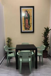 a table and chairs with a picture on the wall at Hotel Matias Real in Buga