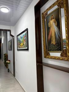 a painting of a woman on a wall in a hallway at Hotel Matias Real in Buga