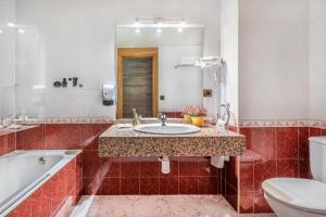 a bathroom with a sink and a tub and a toilet at Cal Ruiz in Pas de la Casa