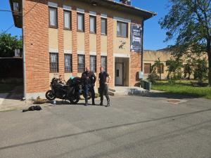 two men standing next to a motorcycle in front of a building at Jois Apartments Periam in Periam