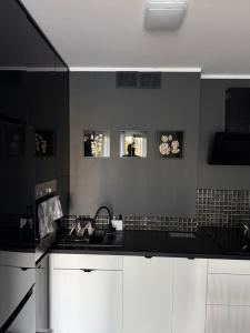 a kitchen with white cabinets and a black counter top at Apartament Bald1 in Kąty Wrocławskie