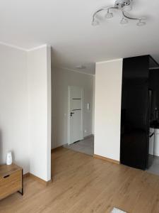 an empty living room with white walls and wooden floors at Apartament Bald1 in Kąty Wrocławskie