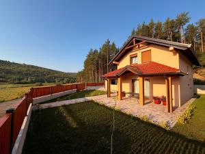 a small house with a fence next to a yard at Kuća za odmor Bruna in Livno