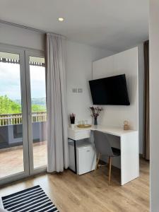 a room with a desk with a computer and a balcony at Natyra e Qetë Hideaway in Lezhë