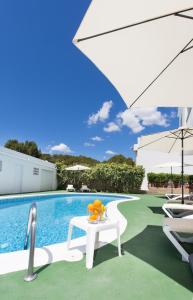 una mesa blanca con naranjas junto a una piscina en Apartamentos Sofía, en Es Canar