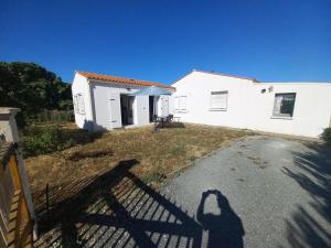 a shadow of a person standing in front of a house at Échappée iodée et nature à l'Île d'Oléron in Saint-Georges-dʼOléron