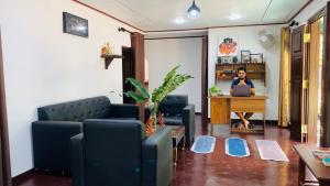 a woman sitting at a desk with a laptop in a room at Mist Mountain Hiking Base in Pimbura +12 photos
