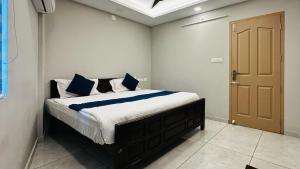a bedroom with a bed with blue and white pillows at AIDAN RESIDENCY - AC Premium Rooms in Alwaye +17 photos