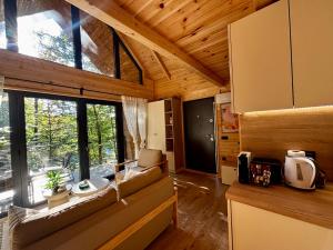 a living room with a couch and a large window at Love Cabin in Slatina Varoš