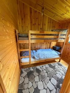 a room with two bunk beds in a wooden cabin at Domki pod Brzozą in Czarnocin