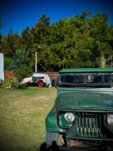 an old green car is parked in a yard at Tano in Villa Gesell