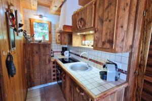a kitchen with wooden cabinets and a sink at Chalets Shangrila in Saint-Michel-de-Chaillol +99 photos