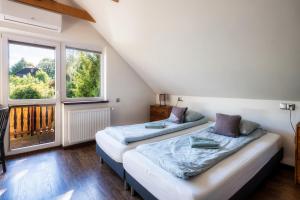 two beds in a room with a window at Ski House Szczyrk - Centrum in Szczyrk