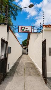 an alleyway between two white buildings with a gate at Moka Refúgium-Casa de praia aconchegante e espaçosa in Belém +22 photos