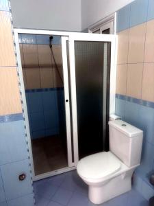 a bathroom with a toilet and a glass shower at Vila Merkuri - 3-Storey Villa with Sea View in Vlorë +55 photos