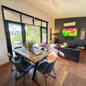 a living room with a table and chairs and a couch at Nature Resort Villas - Villas with a View in Cowes