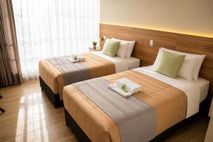 two beds in a hotel room with two trays on them at BRIX Hotel in Arequipa