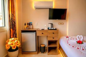 a small room with a desk and a bed with a television at Tropitel Pyramids View Hotel in Cairo