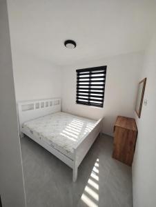 a white bedroom with a bed and a window at Azur Apartments Bar in Bar