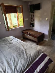 a bedroom with a bed and a wooden table at Petit cocon in Laignes