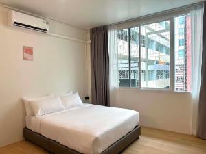 a bedroom with a white bed and a window at April Ari-Saphankhwai in Bangkok