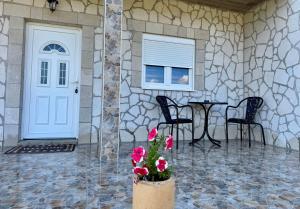a front door of a house with a table and chairs at A&A Durmitor Apartments in Žabljak